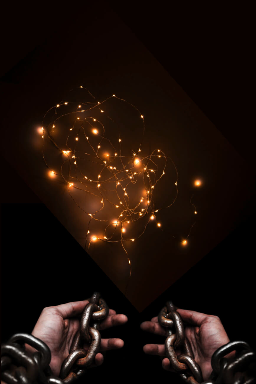 KL Tarot. Hands holding chains below glowing, tangled fairy lights against a dark background.